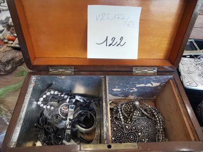 a wooden box filled with lots of jewelry on a table