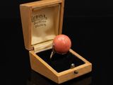 une image représentant une bague dans un coffret en bois posé sur une surface noire