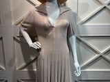 mannequin portant une robe et un chapeau, exposé devant un mur