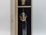 une bouteille de vin dans un coffret en bois orné d'un masque