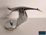 a metal sculpture of a bird that is on top of a table