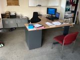 a desk with a computer and a chair in a room