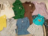 beaucoup de vêtements de bébé qui traînent sur un lit