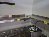 a stainless steel sink in the corner of a kitchen
