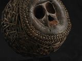 un gros plan d'un crâne dans une boule tressée posée sur une surface noire