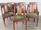 quatre chaises en bois avec des assises recouvertes de velours vert dans une pièce
