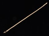 a gold chain with a clasp on a black background
