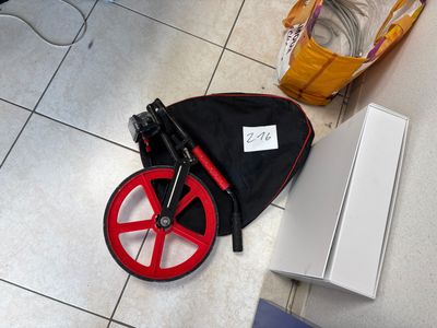 a red wheel on the floor next to a black bag