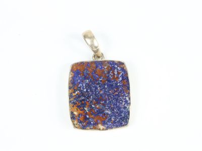 un gros plan d'un pendentif en pierre bleue et orange sur fond blanc