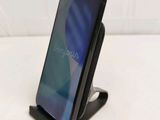 a close up of a cell phone on a stand on a white surface