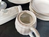 a lot of white plates and cups on the table