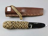 a knife with a rope wrapped around it on a table