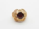 an image of a gold ring with a garnet stone
