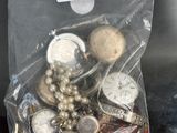 un sac rempli de boutons en argent et en or posé sur une table