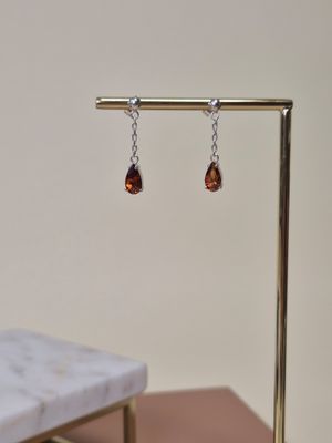 un gros plan sur une paire de boucles d'oreilles posées sur un présentoir sur une table