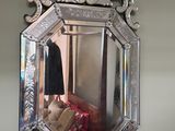 un miroir accroché au mur, avec des bougies et un porte-manteau