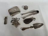 de nombreux objets en argent disposés sur une table blanche