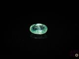 a close up of a green diamond on a black surface