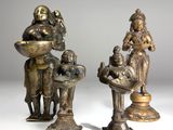 deux figurines en bronze représentant un homme et une femme avec un bébé