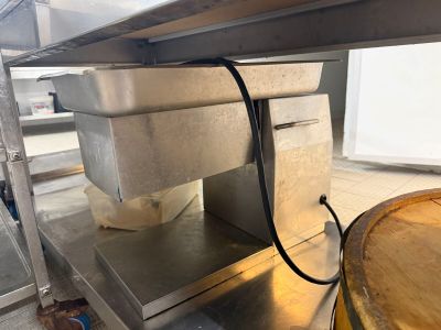 a metal shelf with a bucket on top of it