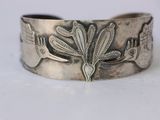 une image représentant un bracelet en argent orné d'un oiseau et de fleurs