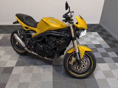 une moto jaune garée sur un sol à damier