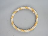 a close up of a white and yellow beaded bracelet on a table