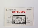 an electronic game watch on a white surface
