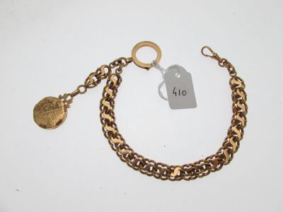 Gros plan sur un bracelet en chaîne en or sur lequel se trouve une pièce de monnaie