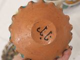 a person holding a brown vase with numbers on it
