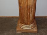 a wooden pedestal with a clock on top of it