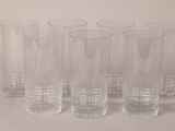 six glasses sitting next to each other on a table