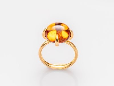 Gros plan sur une bague ornée d'une pierre jaune