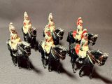 four figurines of soldiers riding on horses