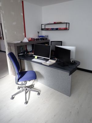 un bureau avec deux ordinateurs et une chaise dans la chambre