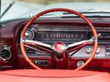 dashboard of a classic car with a red leather seat and steering wheel