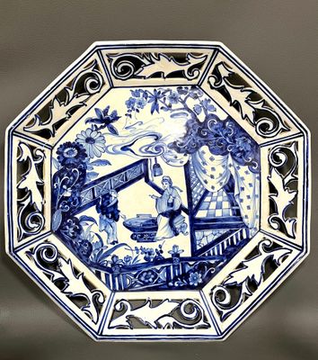 a blue and white plate with a picture of a woman on it