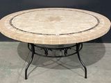 une table ronde avec un plateau en marbre et un piètement en métal