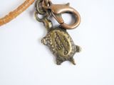 a small turtle charm on a cord with a keychain on it