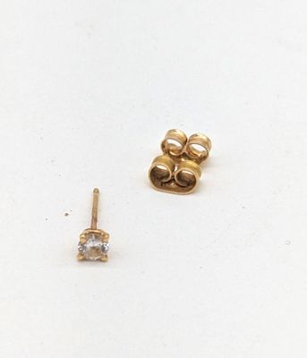 deux paires de boucles d'oreilles en or et diamants posées sur un fond blanc
