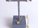 Ensemble collier et boucles d'oreilles « étoile dorée » présenté sur un présentoir