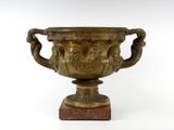 un grand vase en bronze posé sur un socle en marbre