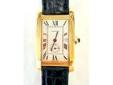 une montre en or avec des chiffres romains, montée sur un bracelet noir