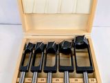 a wooden box with six different tools in it on a white surface