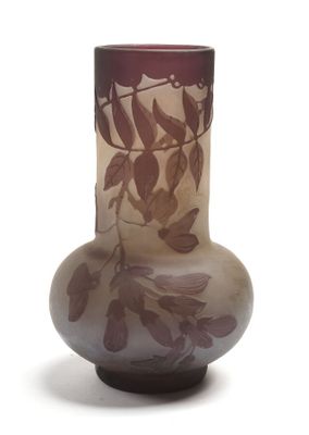 un vase en verre orné de feuilles sur fond blanc
