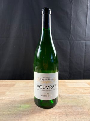 une bouteille de vin blanc posée sur une table en bois