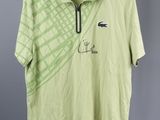 a green polo shirt with a picture of a crocodile on it