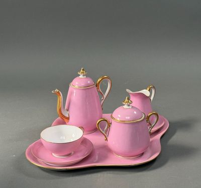 a pink tea set on a tray with a cup and saucer