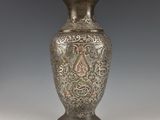 un vase en argent posé sur une table
