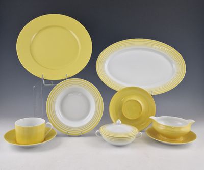 un ensemble d'assiettes, de tasses et de soucoupes jaunes et blanches